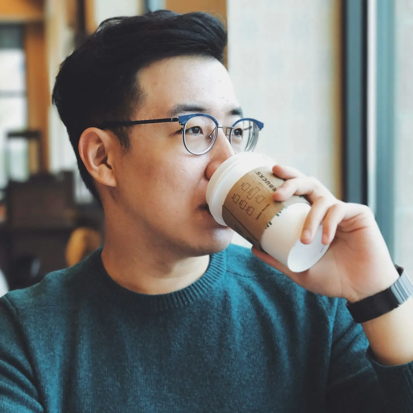 man holding Starbucks disposable cup